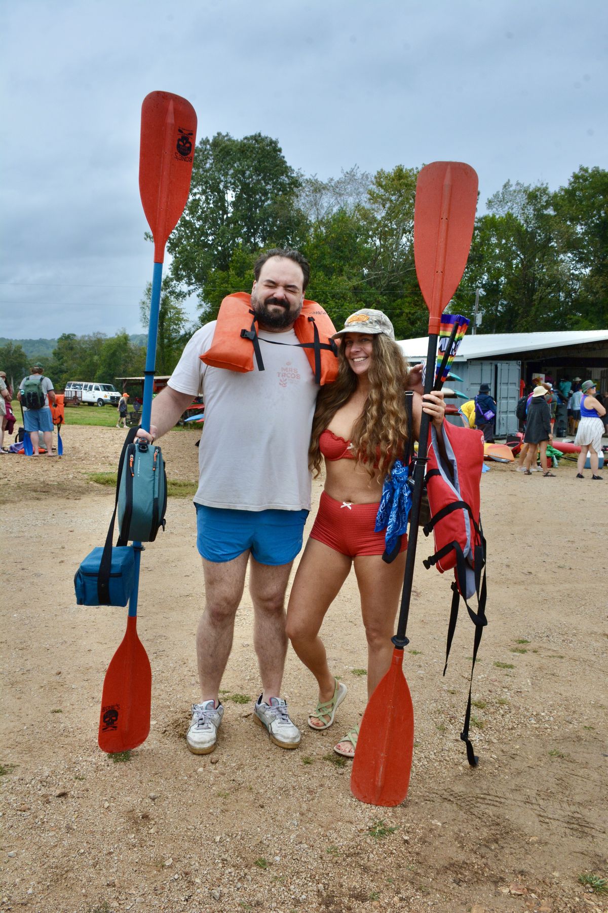Two friends with paddles, life vests on, ready to float