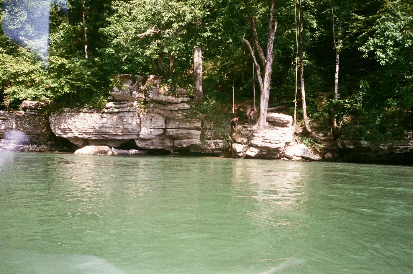 Limestone bluffs over the green water