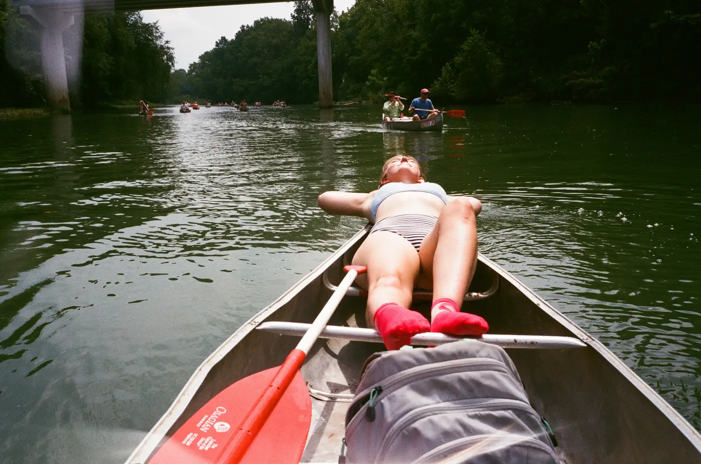 Lying back in a canoe, socks up on the gunwale, river dead ahead