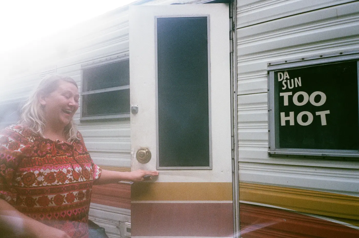 A camper door reading 'Da sun too hot'